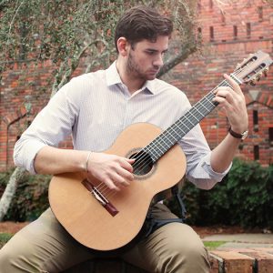 portrait of Eli Denson holding a guitar 