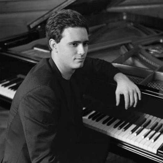 Portrait of Paolo Alderighi sitting on a piano