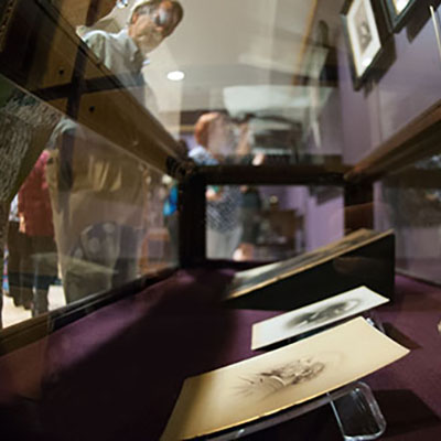Patron viewing etchings in a glass case.