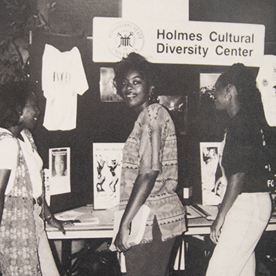 Photo of African-American women at a display about the Holmes Cultural Diversity Center.