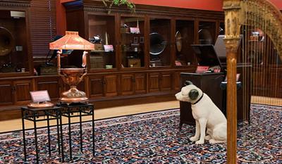 A Victorian-era harp, Nipper the dog statue, and phonograph players in the main gallery of the Charles H. Templeton Museum.